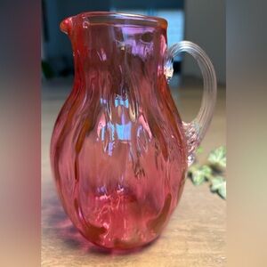 A Small Vintage Cranberry pitcher with clear swirle clear handle.